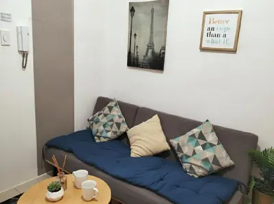 a couch with pillows on it in a living room at Mall of Asia - Aseana Nice and Cheap Apartment in Manila