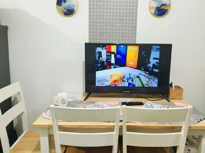 a table with two chairs and a television on it at Mall of Asia - Aseana - Walking Distance to Mall in Manila