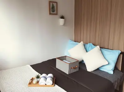 a bed with pillows and a tray with a box on it at Mall of Asia - Aseana - Walking Distance to Mall in Manila