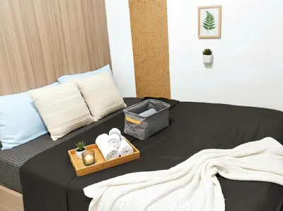 a bedroom with a bed with a tray of towels at Mall of Asia - Aseana - Walking Distance to Mall in Manila