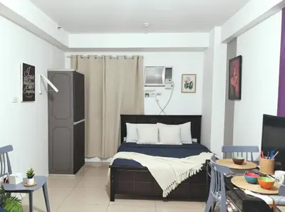 a bedroom with a bed and a table and chairs at Value for Money Mall of Asia - Aseana City Center in Manila