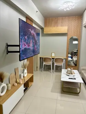 a living room with a tv on the wall at Stylish Comfy and Cozy in Manila