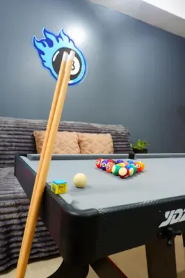 a pool table with a pair of wooden bats at Azure Staycation By Star in Manila