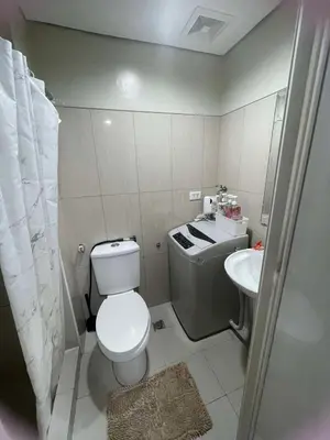 a small bathroom with a toilet and a sink at 1441-Pool view 1BR 1 sofa Bed 1 Extra mattress in Manila
