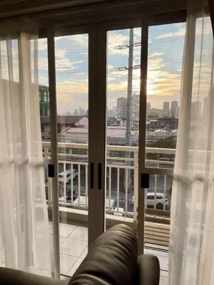a living room with a view of the city from a window at 5 Star Luxury Condo - Metro Manila in Manila