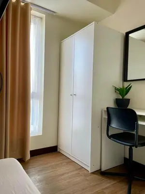 a bedroom with a white cabinet and a black chair at 5 Star Luxury Condo - Metro Manila in Manila