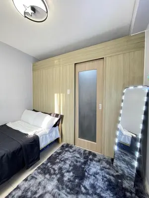 a bedroom with a bed and a sliding glass door at Dandelion Shore Residences 1BR in Manila