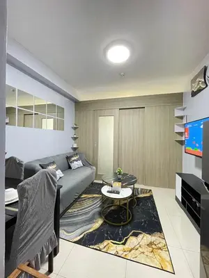 a living room with a couch and a tv at Dandelion Shore Residences 1BR in Manila