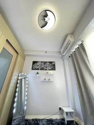 a room with a ceiling with a clock and a window at Dandelion Shore Residences 1BR in Manila