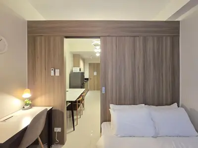 a bedroom with a bed and a table and a dining room at 1BR Condotel with Balcony at FAME Residences #FM10 in Manila