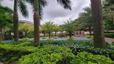 a resort with palm trees and a swimming pool at Levina Place 2BR Resort inspired in Manila