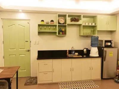 a kitchen with white cabinets and a green door at 1 BR Condo in Quezon City at Avida New Manila in Manila