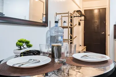 a table with plates and silverware on top of it at Prime Studio Unit at Robinson Magnolia 5 mins Walk to Mall-Netflix-KTV-WiFi in Manila