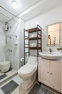 a white bathroom with a toilet and a sink at Prime Studio Unit at Robinson Magnolia 5 mins Walk to Mall-Netflix-KTV-WiFi in Manila