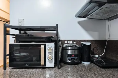 a microwave and a coffee maker on a counter at Prime Studio Unit at Robinson Magnolia 5 mins Walk to Mall-Netflix-KTV-WiFi in Manila