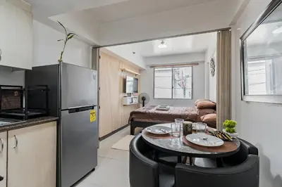 a kitchen and living room with a table in a room at Prime Studio Unit at Robinson Magnolia 5 mins Walk to Mall-Netflix-KTV-WiFi in Manila