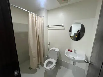 a bathroom with a toilet and a sink and a mirror at Covent Garden Condo 2117 in Manila