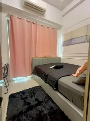 a bedroom with a bed with a window and a rug at Cozy room for couple and family near mall of asia in Manila