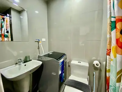 a white bathroom with a sink and a toilet at Air Residence Makati Cozy City View in Manila