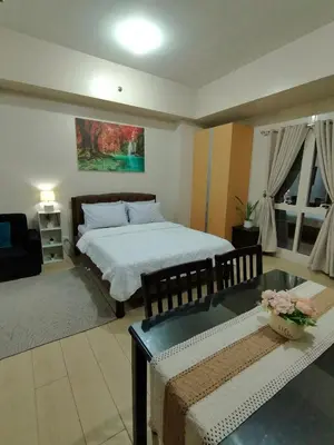 a bedroom with a bed and a couch and a table at Budget Stay Across NAIA TERMINAL 3 C2-5J in Manila