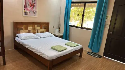 a bedroom with a bed with two green pillows on it at Lenjawi Resort and Events Place in Bitangan
