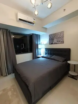 a bedroom with a large bed and a window at Chino Roces Makati - Free Parking - Red Residences in Manila