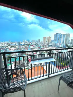 a balcony with a table and chairs and a view of a city at Chino Roces Makati - Free Parking - Red Residences in Manila