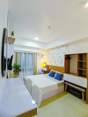 a hotel room with a bed and a desk at The Beacon Condo at Makati CBD in Manila