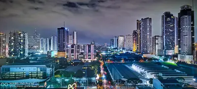 a city lit up at night with tall buildings at Ace Suites by the WaterSpa - Budget Family Room in Manila
