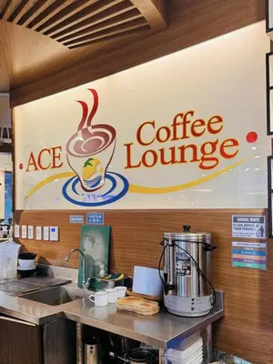 a coffee shop with a coffee lounge sign on the wall at Ace Suites by the WaterSpa - Budget Family Room in Manila