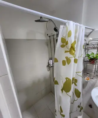 a bathroom with a shower curtain with a sink at MNM Place - Sea Residence 0D in Manila