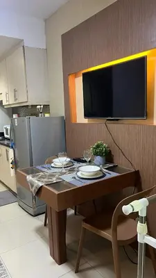 a kitchen with a table with a tv on the wall at MNM Place - Sea Residence 5A in Manila