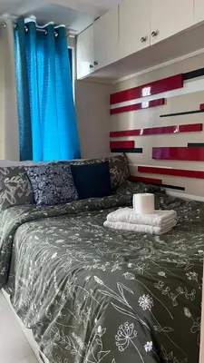 a bedroom with a bed with a gray comforter at MNM Place - Sea Residence 5A in Manila