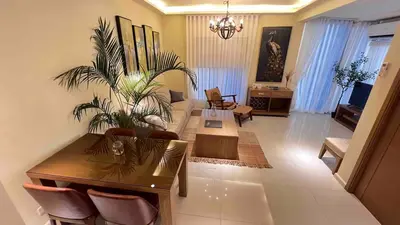 a living room with a table and a plant at 3 Bedroom Beautiful and Spacious Penthouse in Makati in Manila