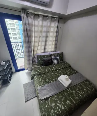 two beds in a room with a window at MNM Place - Sea Residence 9A in Manila