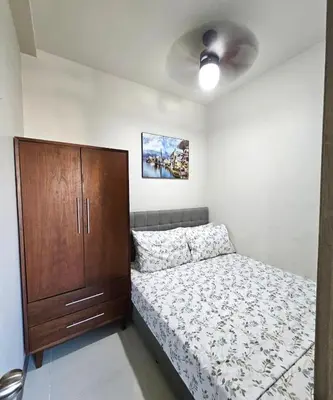 a bedroom with a bed and a wooden cabinet at 2 Br Condo Apartment near PICC, CCP, WTC & Star City at Coast Residences, Pasay City in Manila