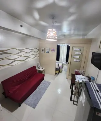 a living room with a red bed in a room at MNM Place - Sea Residence 0A in Manila