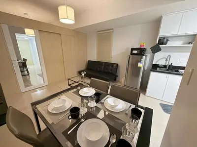 a living room with a table and chairs and a kitchen at Jazz mall Tower 4 Rm 323 Spacious 1 bedroom with Balcony netflix 100mbps in Manila