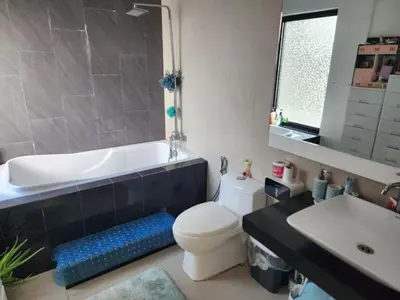 a bathroom with a tub and a toilet and a sink at Family room with private pool in Manila