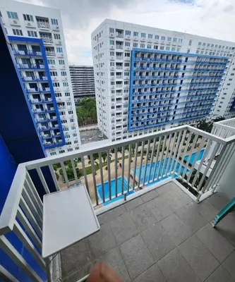 a balcony with a white railing and two tall buildings at MNM Place - Sea Residence 0F in Manila