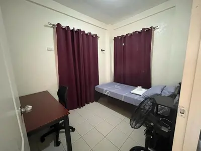 a small room with a bed and red curtains at NRD Staycation Transient House in Dasmariñas