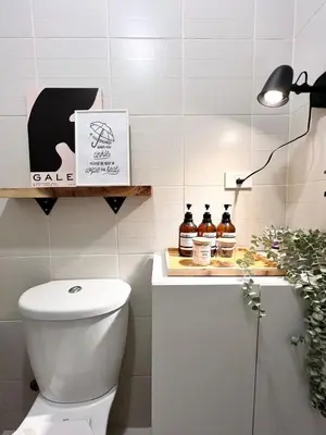 a bathroom with a toilet and a table with bottles of whiskey at Jazz Residence T2 Rm 405 Homey Muji Inspired Staycation Big Screen Cinema in Manila