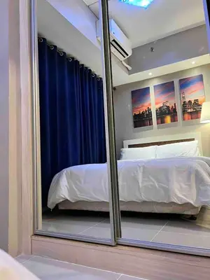 a bedroom with a large mirror in front of a bed at Makati Room 381 1 br deluxe SMJazz T2 residence New in Manila