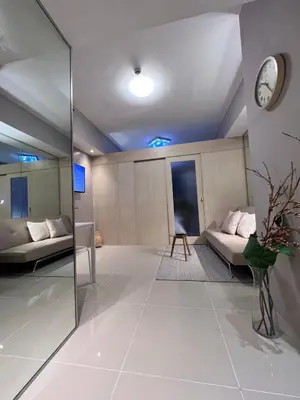 a large living room with a clock on the wall at Makati Room 381 1 br deluxe SMJazz T2 residence New in Manila