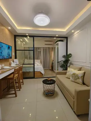 a living room with a couch and a table and a bedroom at Cozy Simple Room by Metro Staycation in Manila
