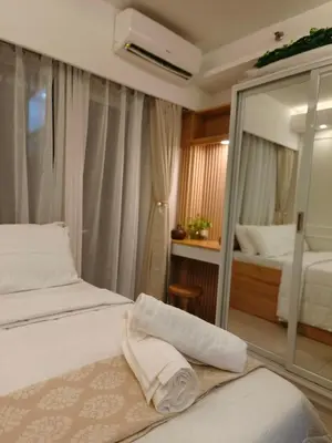 a hotel room with two beds and a mirror at Cozy Simple Room by Metro Staycation in Manila