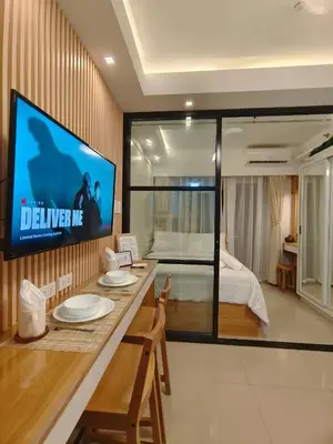 a living room with a television and a bedroom at Cozy Simple Room by Metro Staycation in Manila
