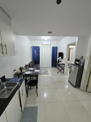 a kitchen and living room with a table and chairs at MNM Place - Sea Residence 8D in Manila
