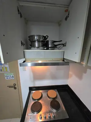 a stove top oven with two pots on top of it at MNM Place - Sea Residence 8D in Manila