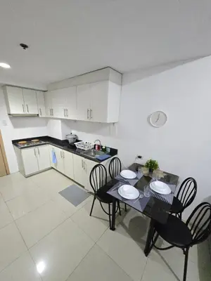a kitchen with a table and chairs in a room at MNM Place - Sea Residence 8D in Manila